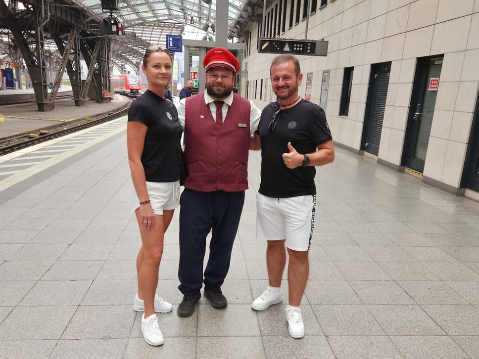 Michael Klede (Mitte) mit dem Ehepaar Karoń am Gleis 1 des Kölner Hauptbahnhofs.