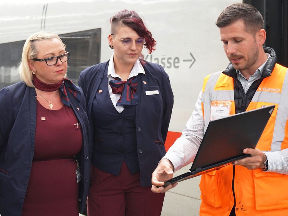 Trainer zeigt den Kolleginnen etwas am Laptop.