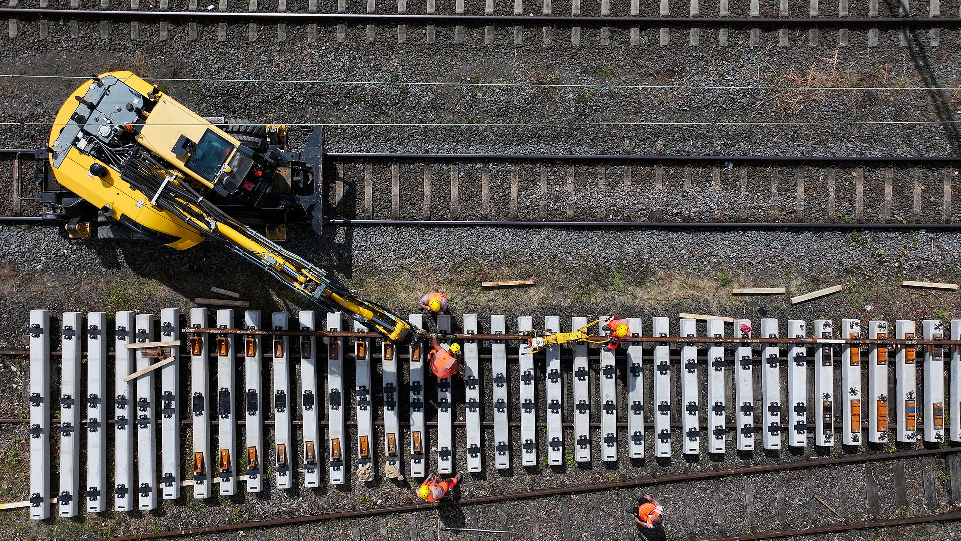 Arbeiter und Baufahrzeug an Schwellen und Schienen bei Gernsheim.