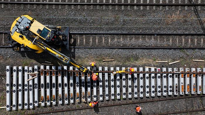 Arbeiter und Baufahrzeug an Schwellen und Schienen bei Gernsheim.