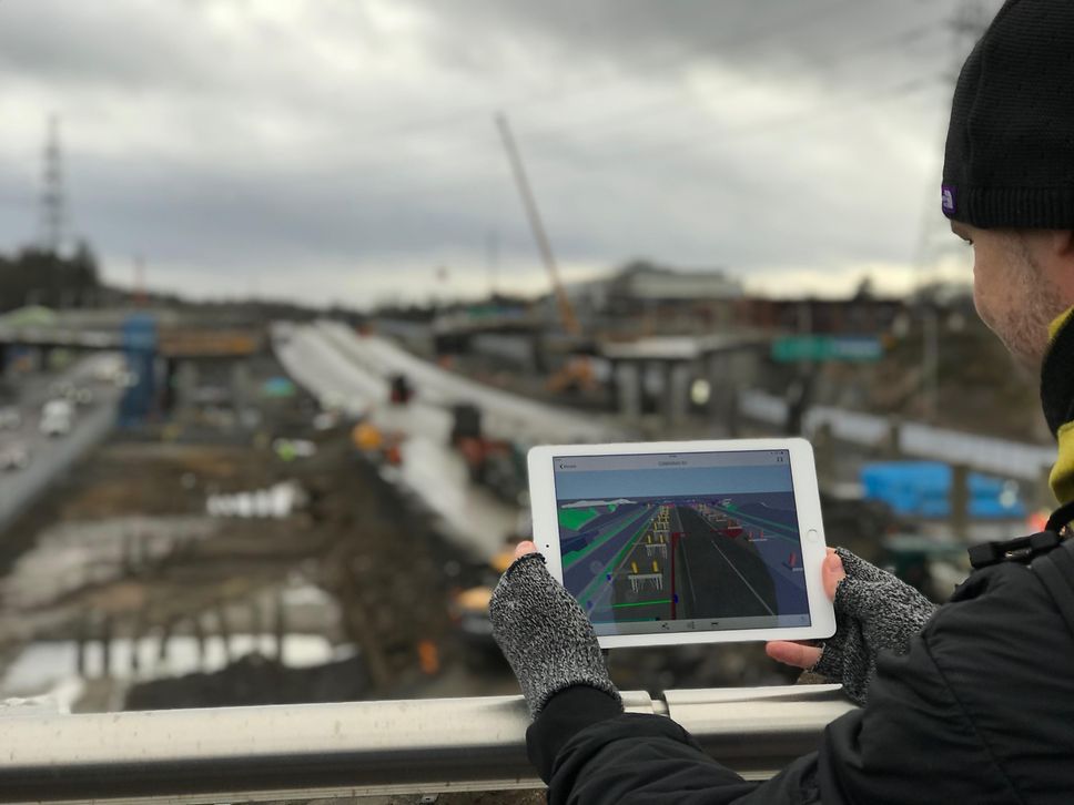 Mitarbeiter nutzt ein Softwaretool auf dem Tablet, um die Abläufe auf der Baustelle zu optimieren